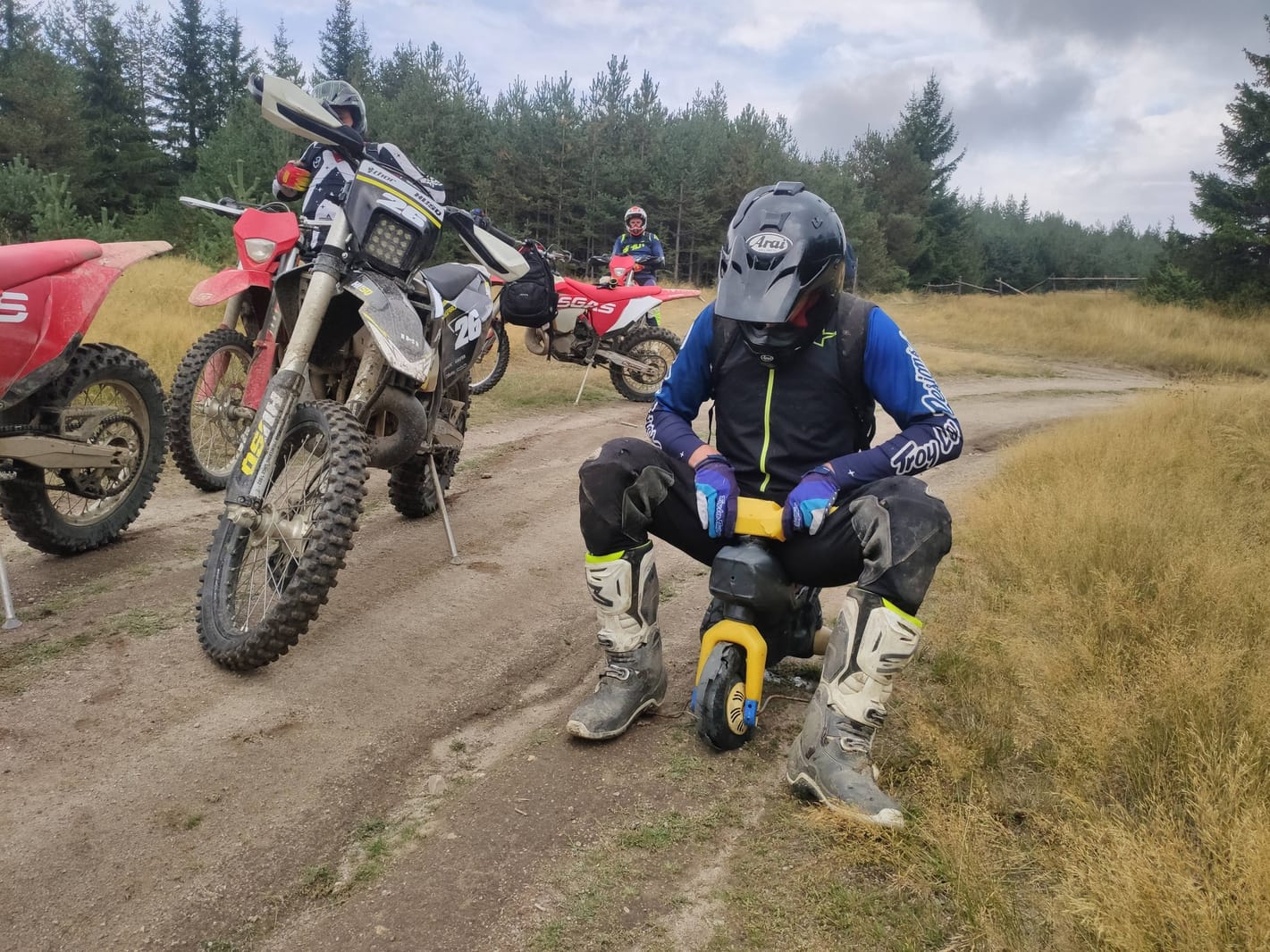 Enduro riding kit laid out before a Bansko tour — helmet, jacket, gloves, knee braces, boots