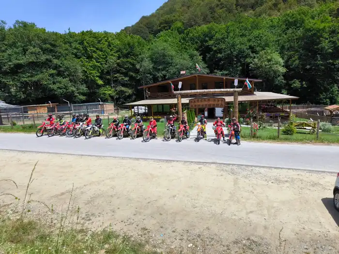 Enduro tour group resting with Pirin Mountains scenery behind