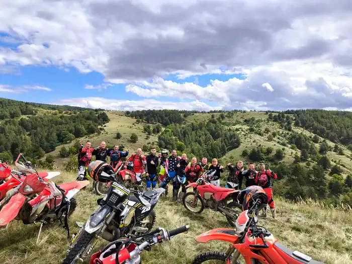 Guided enduro tour group crossing a forest trail in Bulgaria