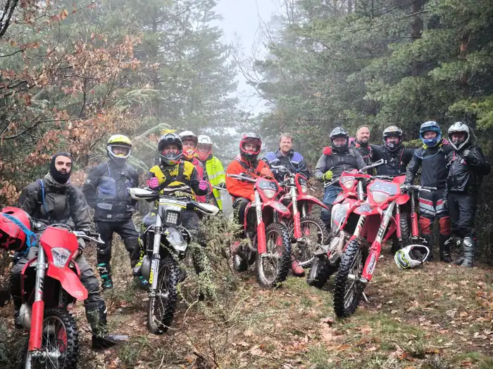 Enduro tour group resting with Pirin Mountains scenery behind