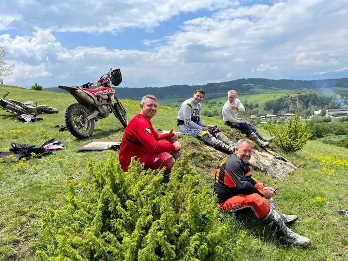 Enduro tour group resting with Pirin Mountains scenery behind