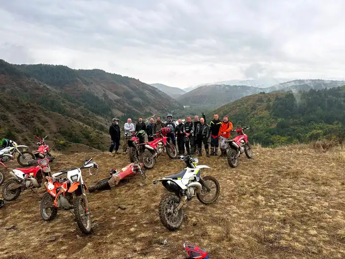Guided enduro tour group crossing a forest trail in Bulgaria